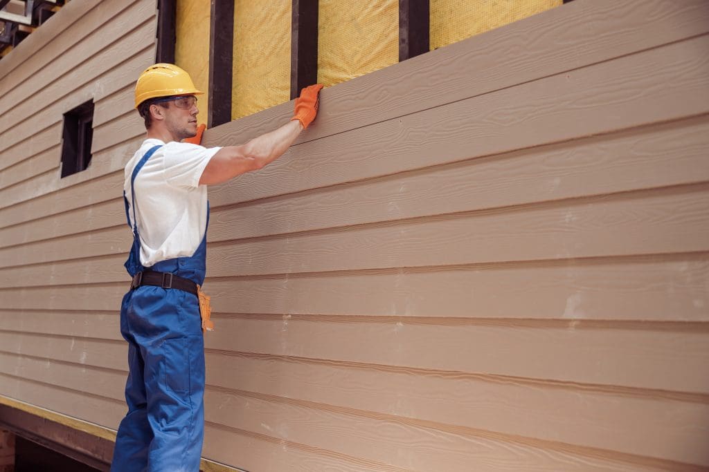a man putting up siding